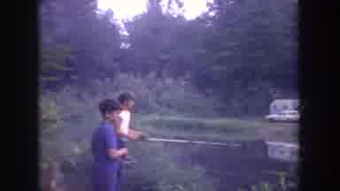 Michigan USA (1968): Teen Boys Fishing In Quiet Stream Across From Parked Camper