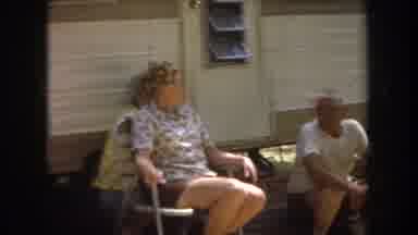 Michigan USA (1968): People Sitting Talking By Camper Waiting For Barbecue Food On