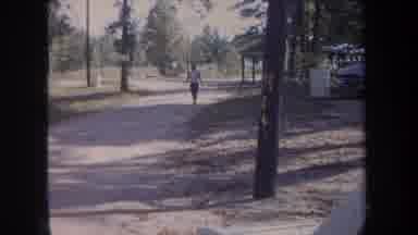 Michigan USA (1968): Woman In A White Shirt Walks Alone Down A Street