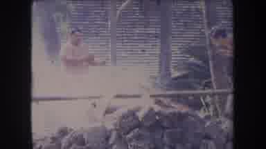 Hawaii USA (1969): Men Outside Covering Smoke With A Large Blanket