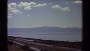 Western USA (1980): Cars Driving On A Road Then A Quick Cut To A Field