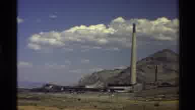 WESTERN USA-1980: Big Factory With Its Erect Smoke Tower Near To A Mountain
