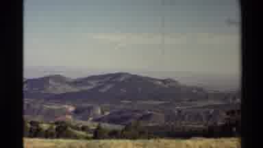 Western USA (1980): Grassy Plain Runs To A Mountain Range With A Light Blue Sky