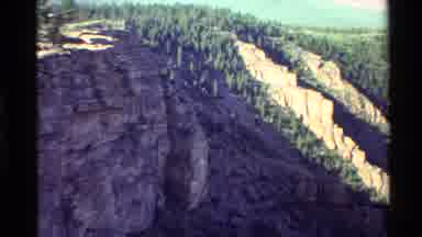 Western USA (1980): Distant Mountain Range With Trees Sloping Down A Hill Sunlight