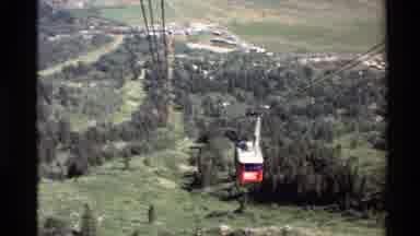 Western USA (1980): Aerial Tram Car Going Down Into A Green Valley Below And Up