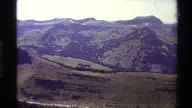 Western USA (1980): Dirt Road Winds Through Mountains Covered In Grass And Trees