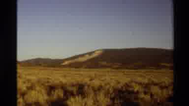 Western USA (1980): High Desert Field Filled With Sagebrush Runs To A Mountain