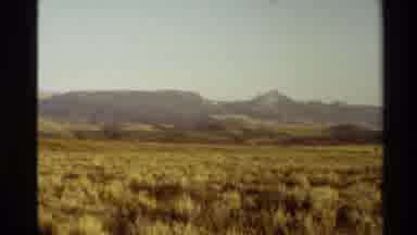 Western USA (1980): Mountains With Peaks And Golden Plains Under A Hazy Sky