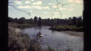 Western USA (1980): Rowboat On A River With A Man Rowing And Clouds Above
