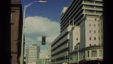 New Zealand (1981): Tall Building With Cars Driving Throughout A Busy Street