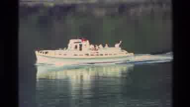 New Zealand (1982): Boat Glides Down The River And Nears A Small Town Built Into A