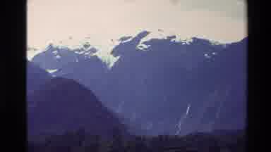 New Zealand (1982): Mountains Are In The Background And There Are Also Green Trees