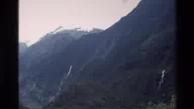 New Zealand (1982): Small Waterfall In Snow Covered Mountains On A Cloudy Day