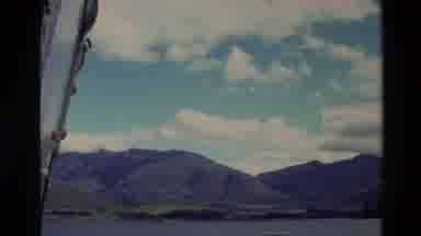 New Zealand (1982): Body Of Water Meets A Mountainous Shore Followed By A Sheep