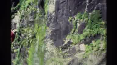 New Zealand (1982): Person On The Left Side Of A Waterfall Cliff With Pan Out Of