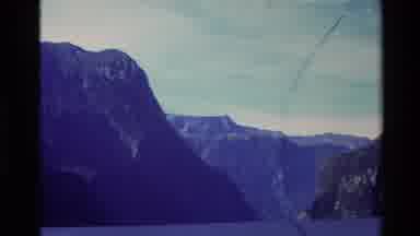 New Zealand (1982): Tourists Cruise Between Large Dark Mountains By Ferry