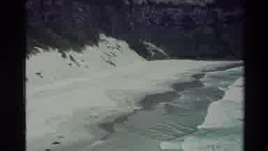 New Zealand (1982): Waves Rolling Onto The Beach With Man Sitting In Sand Watching
