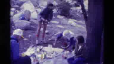 British Columbia USA (1981): 4 People Having A Picnic On The Ground On Top Of A