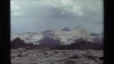 British Columbia USA (1981): Snow Covered Mountain Peaks With Green Hills In