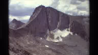 British Columbia USA (1981): Jagged Grey Mountains Sloping Downwards With A Few