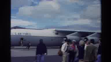 New Zealand-1981: People Talking And Standing By Large Gray Airplane On A Cloudy Day