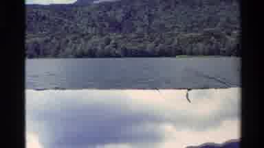 New Zealand (1981): An Overcast Day Over A Lake With Two Dark Ominous Clouds