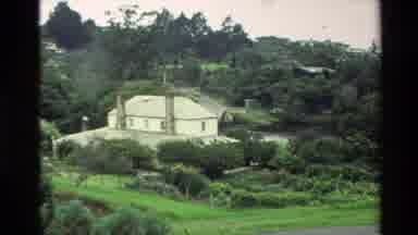 New Zealand (1981): Shot Of A Large House In A Heavily Wooded Area From A Distance