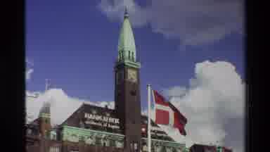 Denmark-1982: Danish Flag Waving In Front Of Historic Clock Tower Building