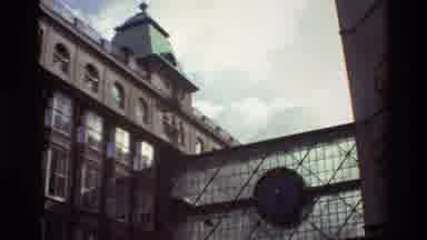Denmark (1982): Tall Building With Bridge And Green Roof Two Women Walking Away