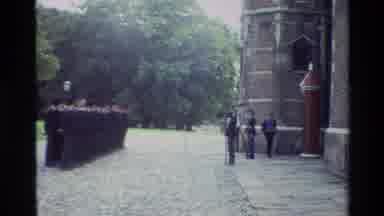 Denmark (1982): Along Aged Stone Streets Armed Uniformed Men March Near A Tall