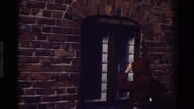 Denmark (1982): Someone In A Black Hoodie Knocks On A Door In A Brick Wall Then A