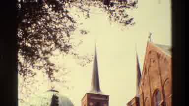 Denmark (1982): Shot Of Architecture Then Person With Large Coat Riding Bike Under