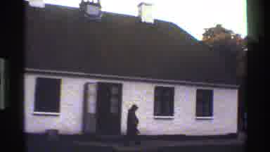 Denmark-1983: Man Walking Past House to Timber-Framed Building