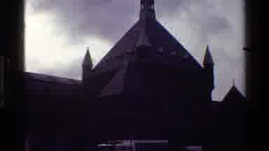 Denmark (1983): People Hurry Through A City And In Front Of A Church