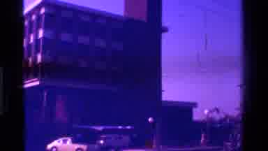 California USA-1975: Tall Building With A Lot Of Windows As Cars Speed By In The