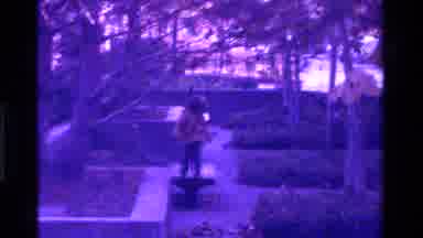 California USA-1975: A Child Is Playing At A Park And A Woman Is Walking