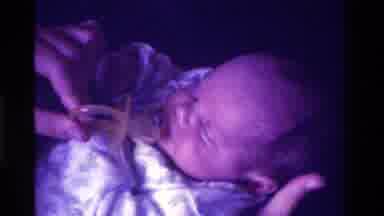 California USA (1975): Young Mother Bottle Feeding Newborn Baby And Giving Baby A