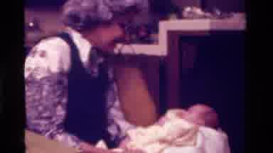 California USA (1975): Two Elderly People Holding And Looking Down At An Infant
