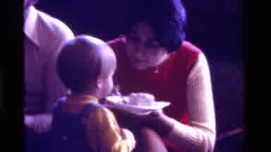 California USA (1975): Small Child Being Offered Cake On A Spoon By Its Mother