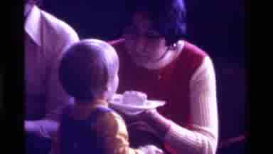 California USA (1975): A Mother Feeds Her Child Some Birthday Cake A Young Man And