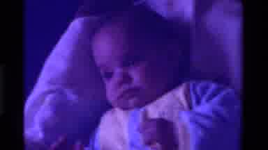 California USA (1975): Little Baby Laying In Rocking Chair Looking Around The Room