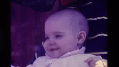 California USA (1975): A Small Cute Baby In White Moving And Kind Of Dancing Like