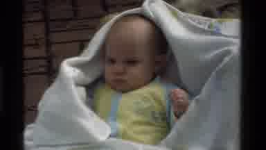 California USA (1975): Baby Wrapped In A Sheet Lying Down Outside In A Basket With
