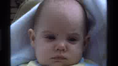 California USA (1975): Unamused Infant Rests Emotionless In Seat Gazing Around The