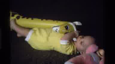 California USA (1975): Toddler In Yellow Onesie Playing With Inflatable Yellow