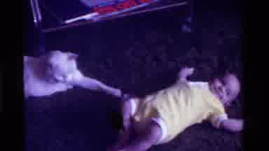 California USA (1975): Baby Dressed In White Lying Down Close To A White Cat