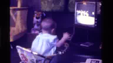 California USA (1975): Toddler Moving In Playcart While Watching Tv