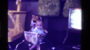 California USA (1975): Baby In A Walker In Front Of An Old Tv And Playpen