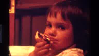 California USA (1977): A Child With Bangs Smiles Coyly And Eats A Jam Covered