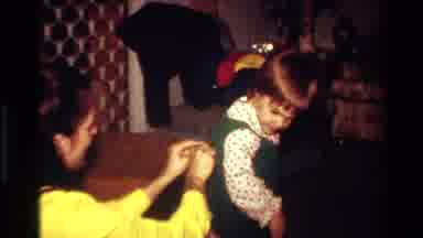 California USA (1977): A Little Girl Plays While A Mother Puts On Her Jumper Dress